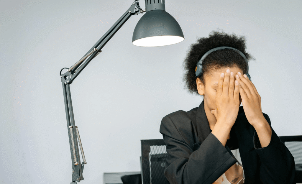 woman touching face tired office light